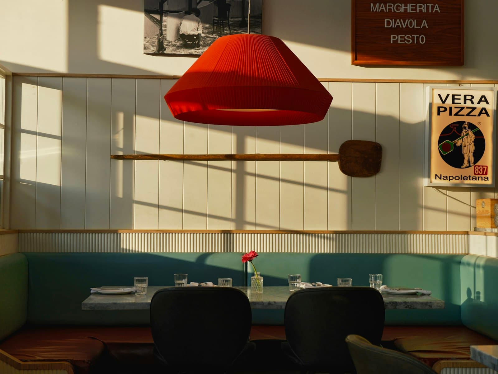 Pizzerians inredning med varma toner och en italiensk pizzaaffisch på väggen